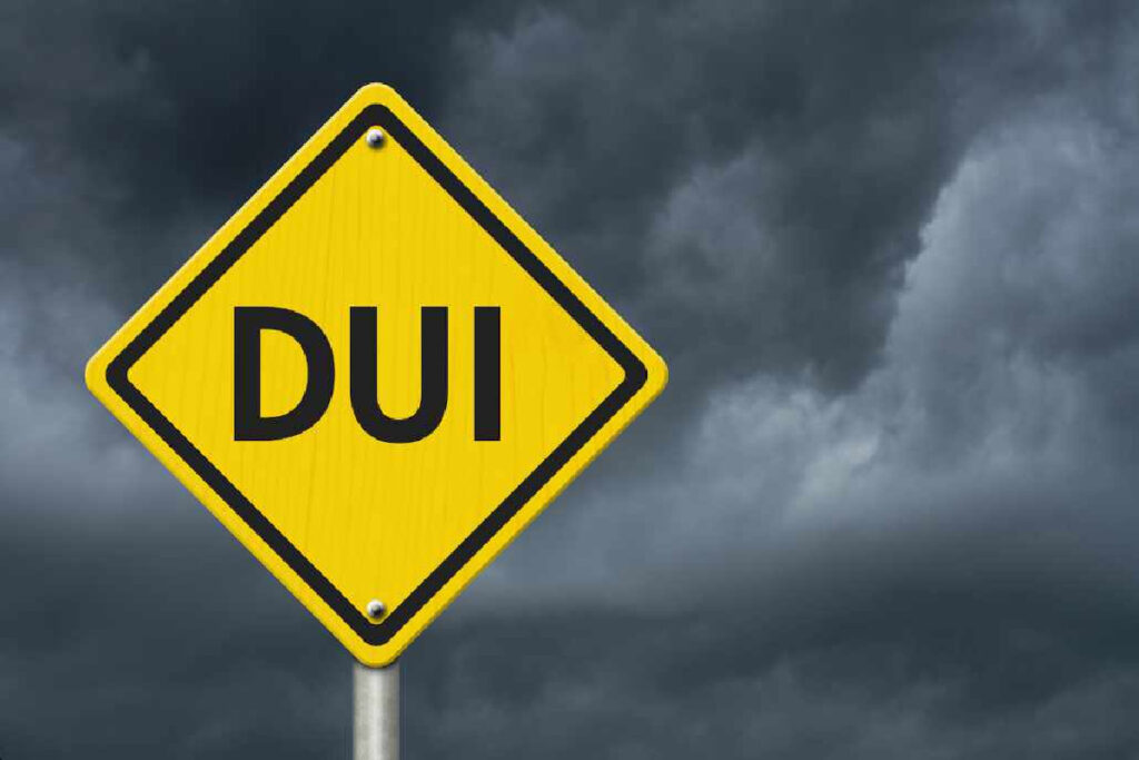 DUI warning sign against a dark stormy sky, symbolizing the legal repercussions of driving under the influence in Texas.