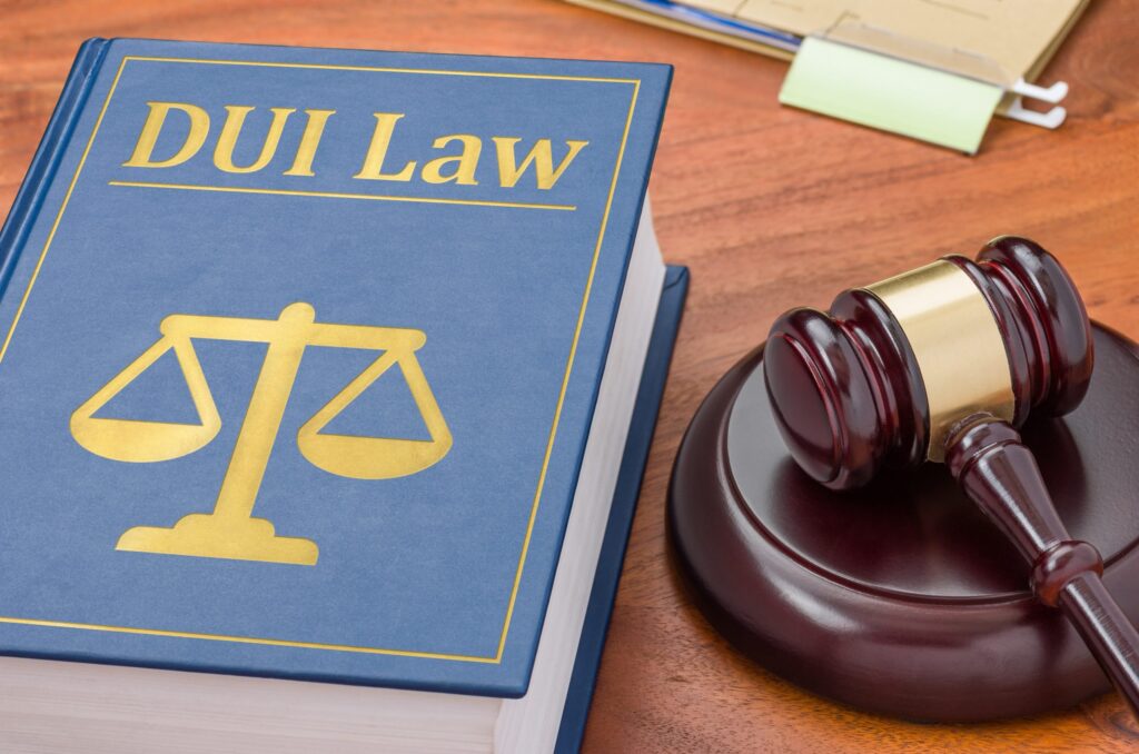 DUI law book with scales of justice and gavel on wooden desk, symbolizing legal implications of DUI convictions in Texas.