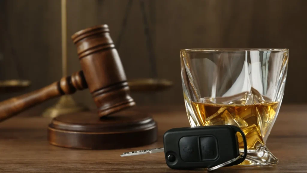 Gavel, whiskey glass with ice, and car keys symbolizing legal consequences of DWI charges in Texas.