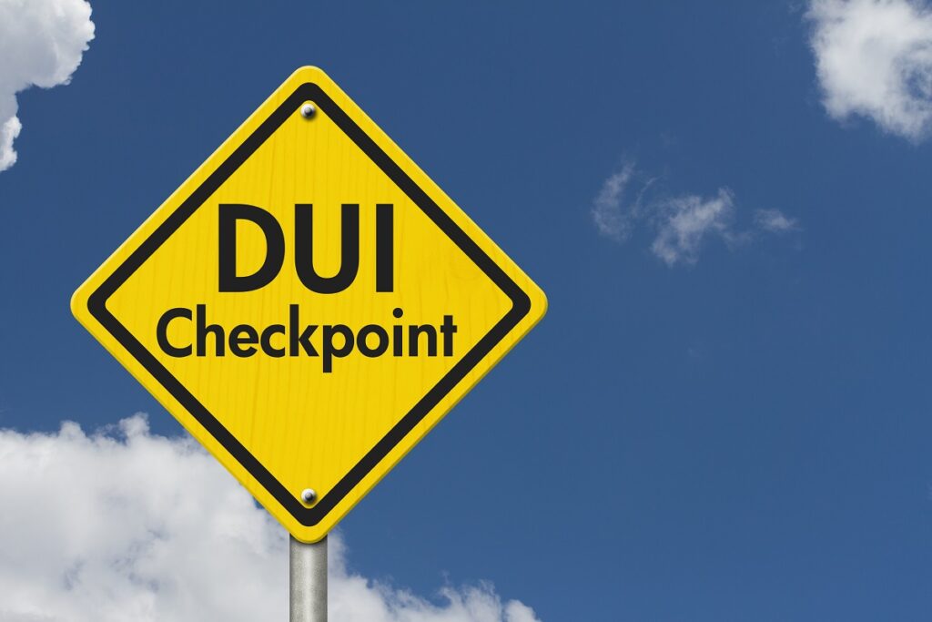 DUI checkpoint warning sign against a blue sky, relevant to DUI legal advice and defense services by Bryan Fagan Law Office.