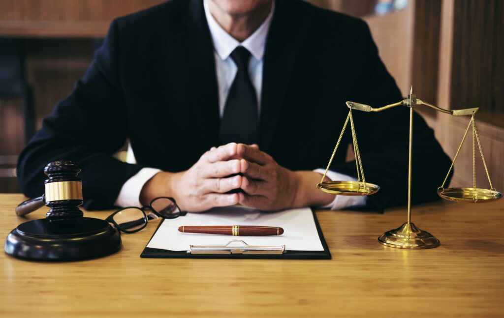 Lawyer sitting at a desk with a gavel, scales of justice, and a pen, symbolizing legal representation and DUI defense in Texas.