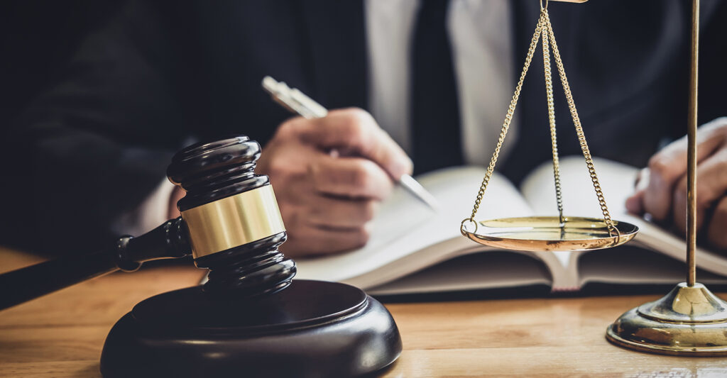 Gavel and scales of justice on a desk with a lawyer reviewing legal documents, symbolizing DUI defense strategies in Texas.