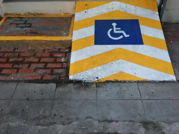 Wheelchair accessible ramp with blue handicap symbol and yellow chevron markings, highlighting accessibility features for clients at Bryan Fagan Law Office in Houston.