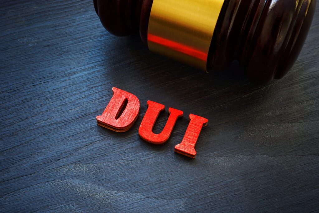 DUI legal implications with wooden letters spelling "DUI" beside a gavel, representing Texas DUI penalties and legal consequences.